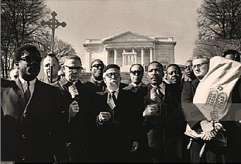 Rabbi Maurice Eisendrath carrying a Torah alongside Dr. Martin Luther King Jr. and Rabbi Abraham Joshua Heschel as part of a Vietnam War protest at Arlington National Cemetery on February 6, 1968.